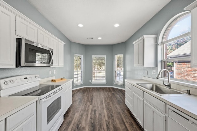 kitchen with white appliances, dark hardwood / wood-style flooring, white cabinets, and sink