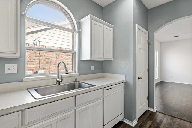 kitchen featuring dark hardwood / wood-style floors, plenty of natural light, white dishwasher, white cabinets, and sink