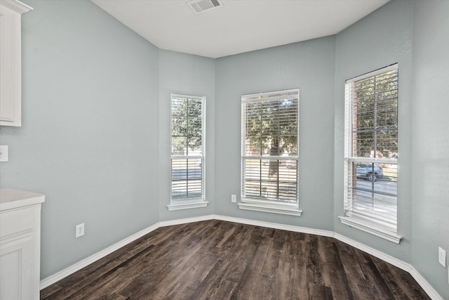 unfurnished dining area with dark wood-type flooring