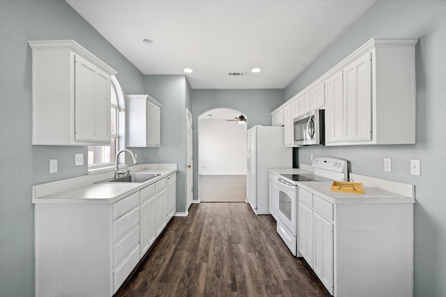 kitchen with white appliances, ceiling fan, dark hardwood / wood-style flooring, sink, and white cabinetry