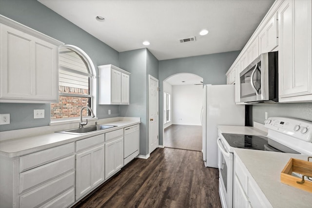 kitchen with white appliances, white cabinets, dark wood-type flooring, and sink