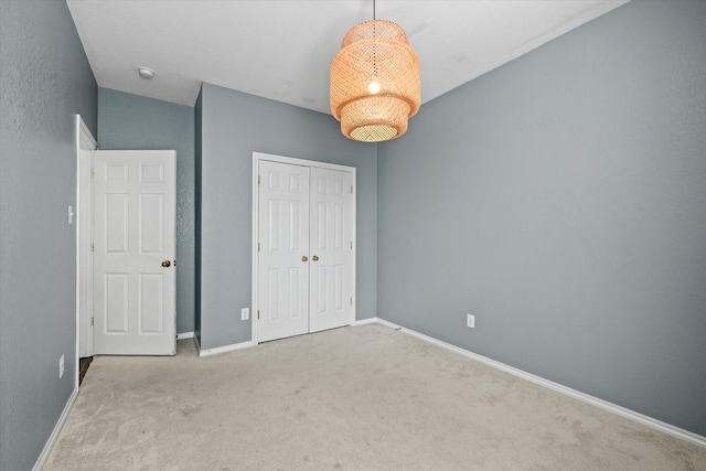 unfurnished bedroom with a closet and light colored carpet