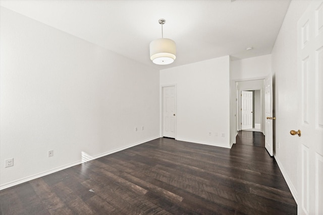 empty room with dark hardwood / wood-style flooring