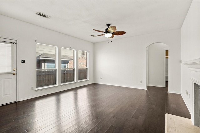 unfurnished living room featuring ceiling fan and dark hardwood / wood-style flooring