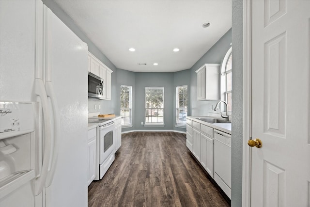 kitchen featuring white appliances, dark wood-type flooring, white cabinets, and sink