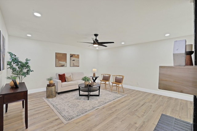 living room with light wood-type flooring and ceiling fan