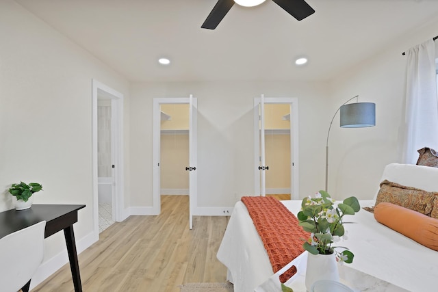 interior space featuring ceiling fan, a walk in closet, light hardwood / wood-style flooring, and a closet