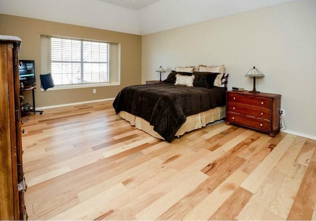 bedroom with lofted ceiling and light hardwood / wood-style flooring