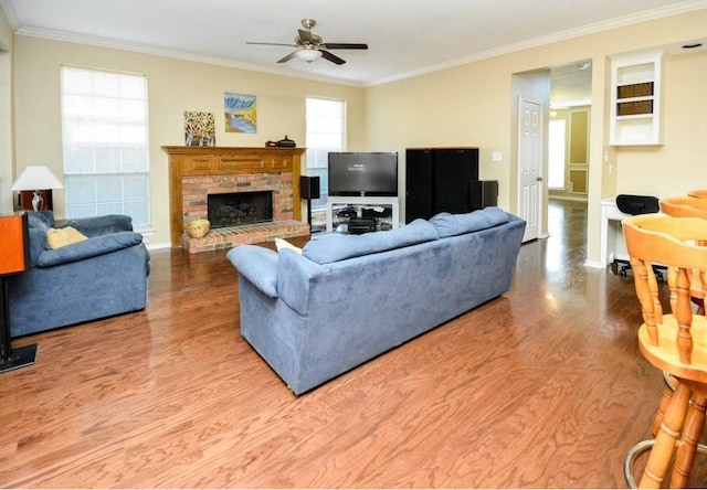 living room featuring ceiling fan, ornamental molding, and a fireplace