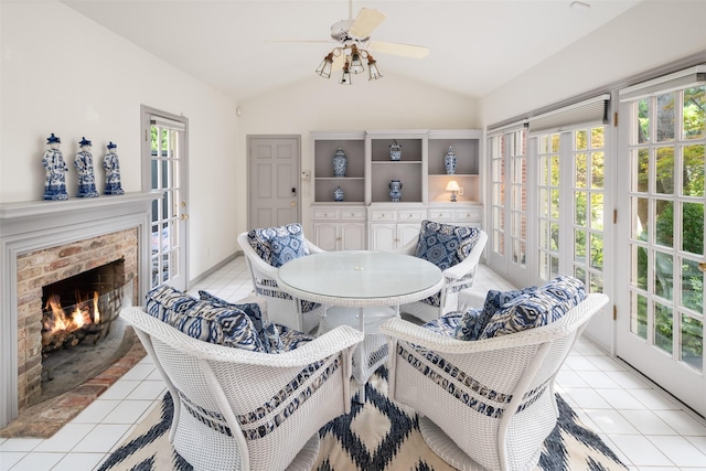 sunroom featuring a fireplace, ceiling fan, and vaulted ceiling