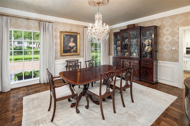 dining space featuring dark parquet flooring, crown molding, a healthy amount of sunlight, and a notable chandelier