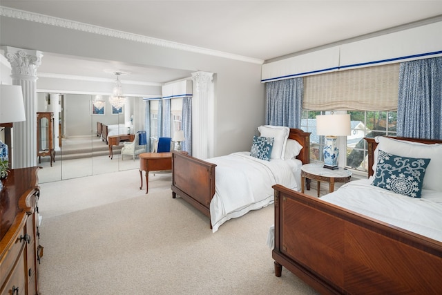 bedroom featuring light colored carpet, crown molding, a chandelier, and ornate columns