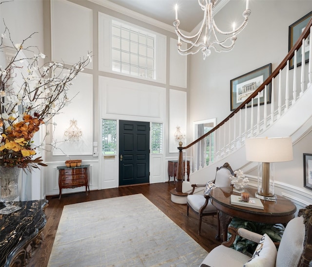 entrance foyer with a towering ceiling, an inviting chandelier, and dark hardwood / wood-style flooring