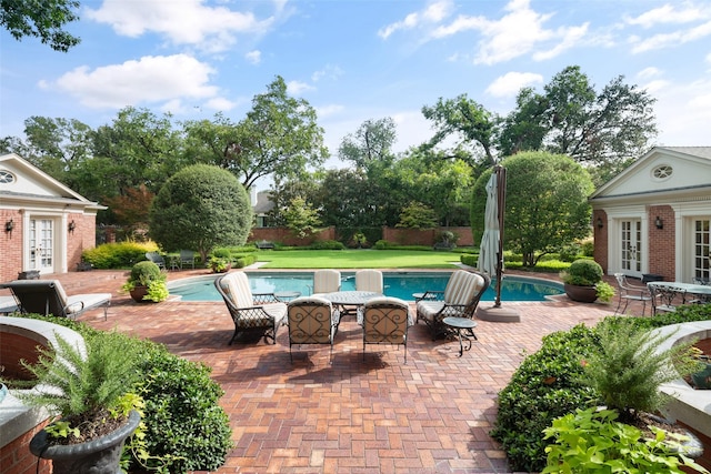 view of swimming pool with french doors, an outbuilding, and a patio