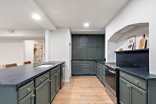 kitchen with dishwasher, electric stove, an island with sink, light hardwood / wood-style floors, and sink