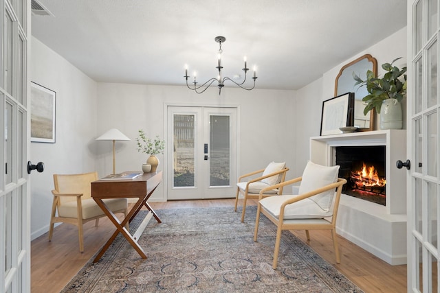 office featuring french doors, an inviting chandelier, and hardwood / wood-style floors