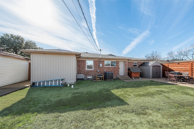 rear view of property with central air condition unit, a lawn, and a shed