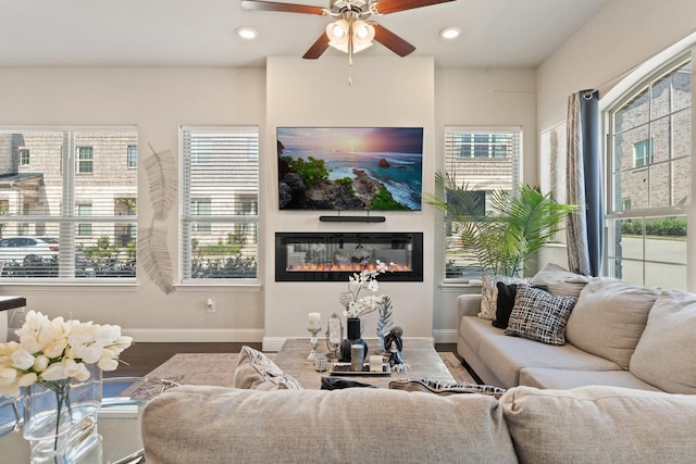 living room featuring hardwood / wood-style flooring, ceiling fan, and plenty of natural light