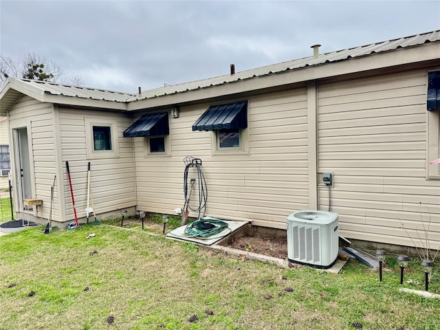 view of home's exterior featuring central AC unit and a yard