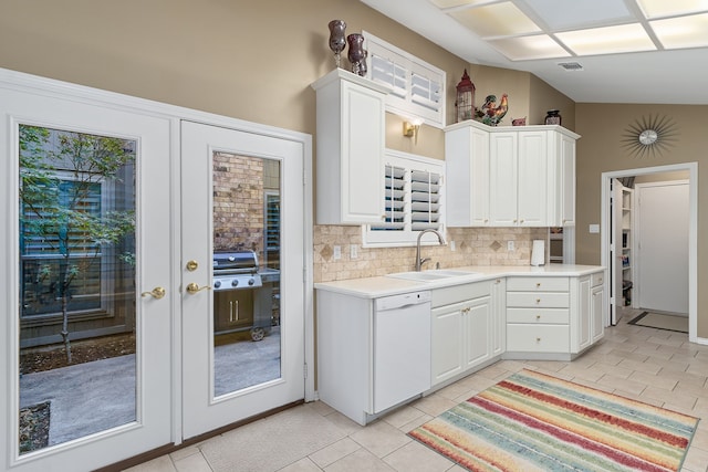 kitchen featuring white cabinets, dishwasher, sink, light tile patterned flooring, and tasteful backsplash