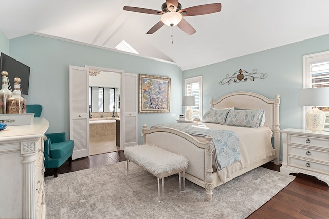 bedroom with connected bathroom, lofted ceiling with beams, ceiling fan, and dark wood-type flooring