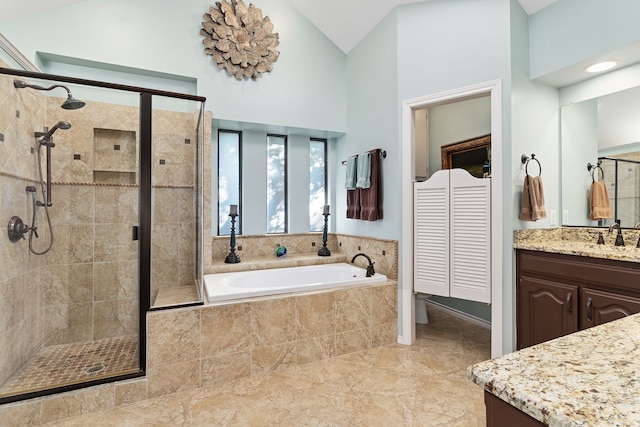 bathroom with high vaulted ceiling, vanity, and shower with separate bathtub