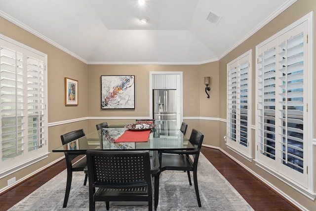 dining room featuring vaulted ceiling, crown molding, and dark hardwood / wood-style flooring