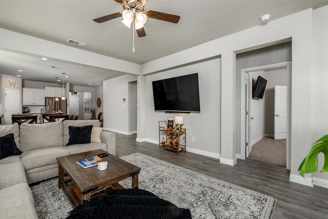 living room featuring dark hardwood / wood-style flooring and ceiling fan