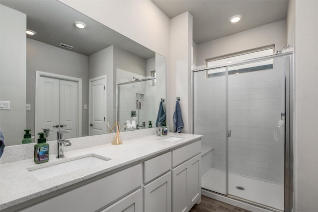 bathroom with an enclosed shower, vanity, and hardwood / wood-style floors