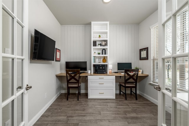 office space featuring french doors, wood walls, and dark wood-type flooring