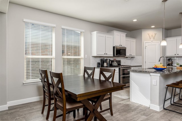 dining room with sink and light wood-type flooring