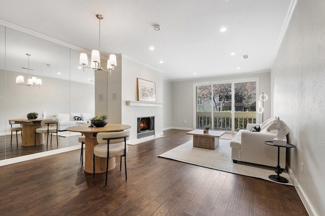 living room featuring ornamental molding, a notable chandelier, and dark hardwood / wood-style flooring