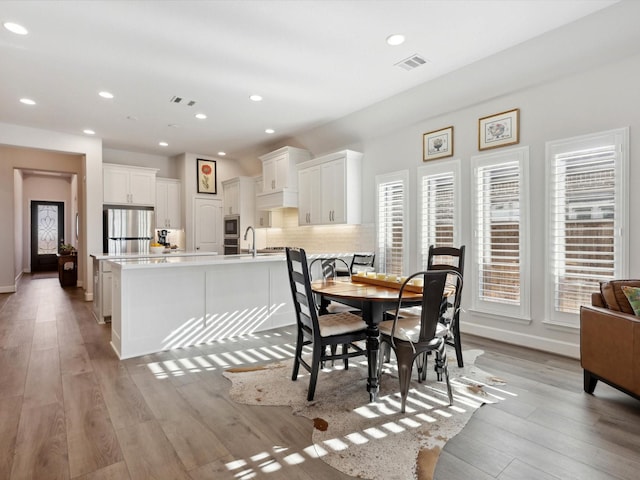 dining room with sink and light hardwood / wood-style floors