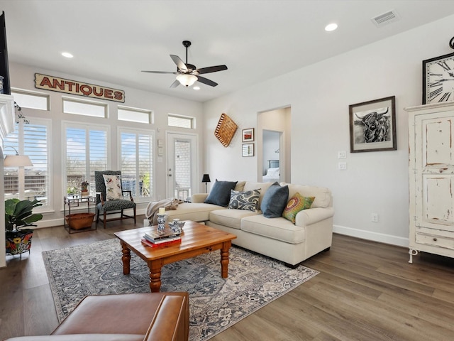 living room featuring ceiling fan and dark hardwood / wood-style flooring