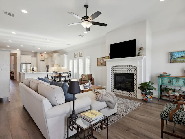 living room with ceiling fan, dark hardwood / wood-style flooring, and a fireplace