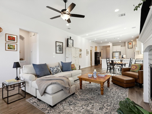 living room with ceiling fan and dark wood-type flooring