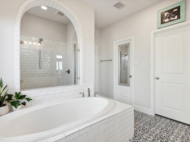 bathroom with shower with separate bathtub and tile patterned floors