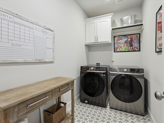 clothes washing area featuring cabinets and independent washer and dryer