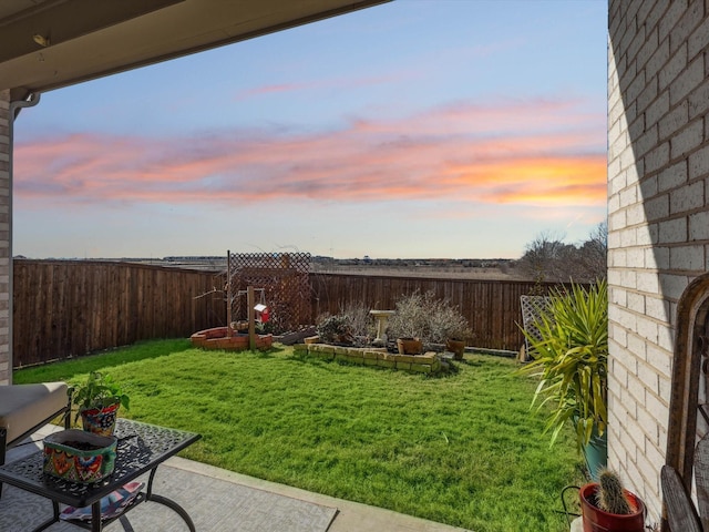 yard at dusk with a patio area