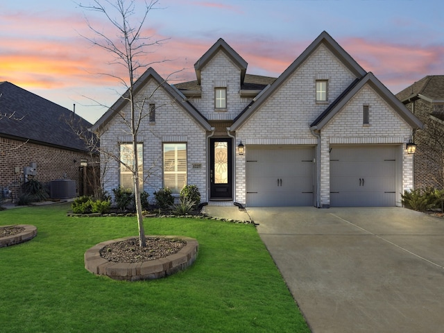 view of front of home with central air condition unit and a yard