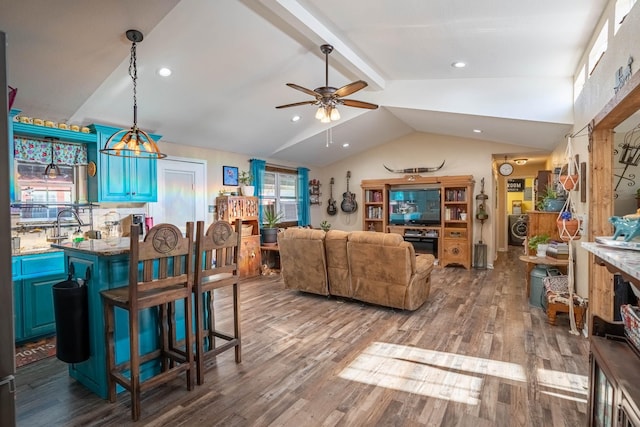 living room with vaulted ceiling with beams, hardwood / wood-style floors, and ceiling fan