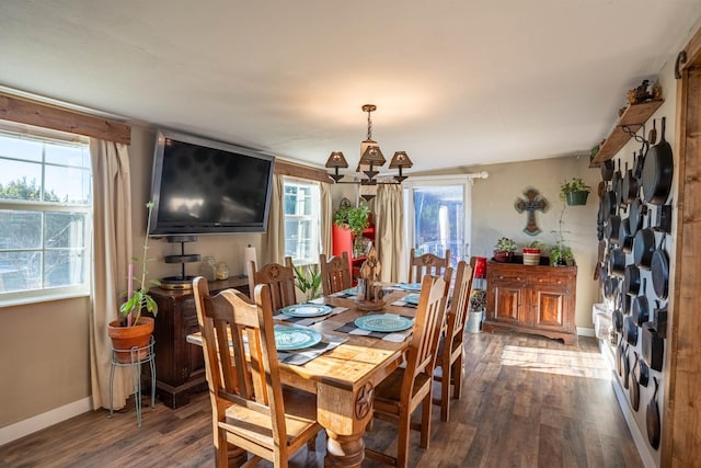 dining area with an inviting chandelier, a healthy amount of sunlight, and dark hardwood / wood-style floors