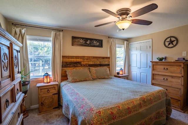 bedroom with carpet, a closet, a textured ceiling, and ceiling fan