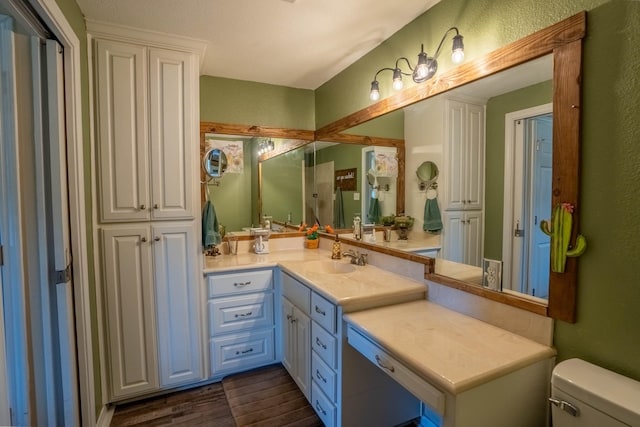 bathroom with toilet, hardwood / wood-style flooring, and vanity