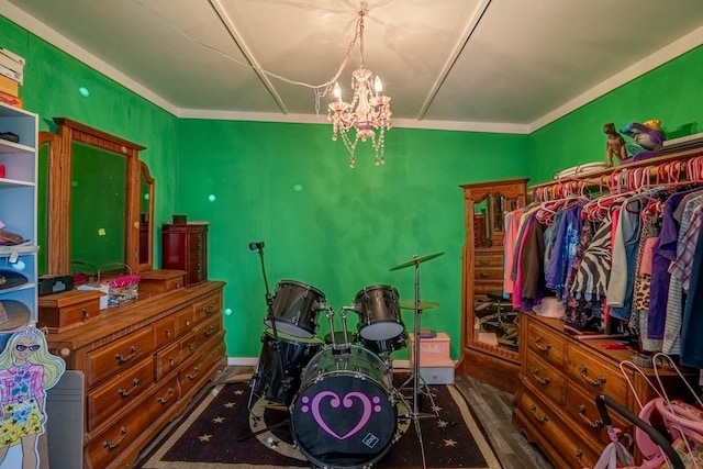 bedroom with hardwood / wood-style flooring, crown molding, and a notable chandelier