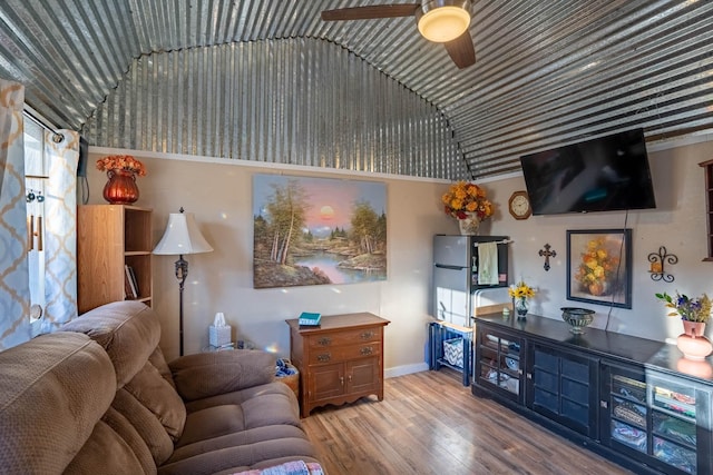 living room featuring hardwood / wood-style floors, vaulted ceiling, and ceiling fan