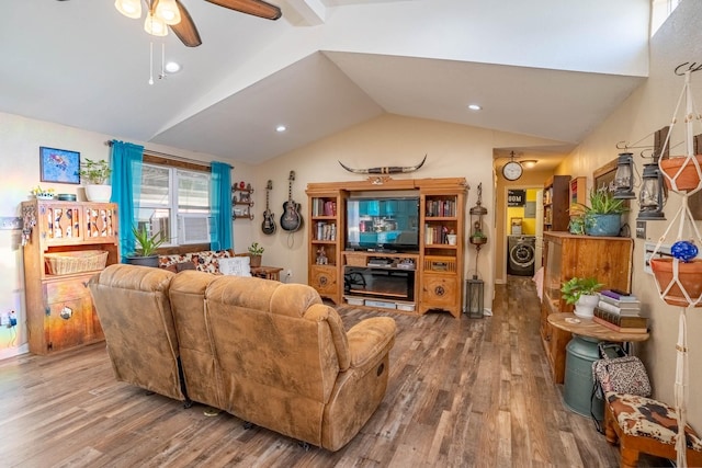 living room with hardwood / wood-style flooring, ceiling fan, vaulted ceiling, and a fireplace