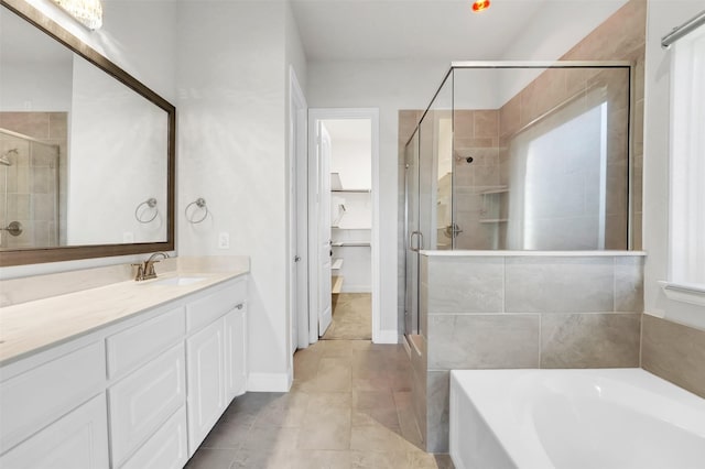 bathroom with tile patterned floors, plus walk in shower, and vanity