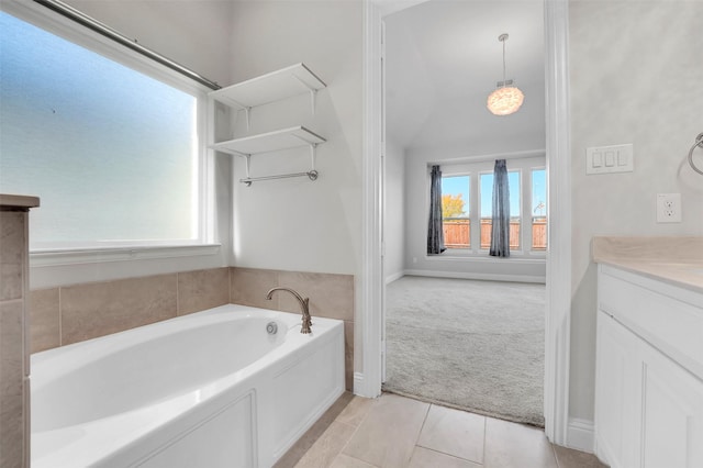 bathroom featuring a bath, tile patterned floors, a wealth of natural light, and vanity