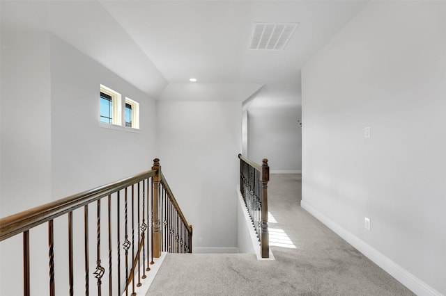 staircase with lofted ceiling and carpet